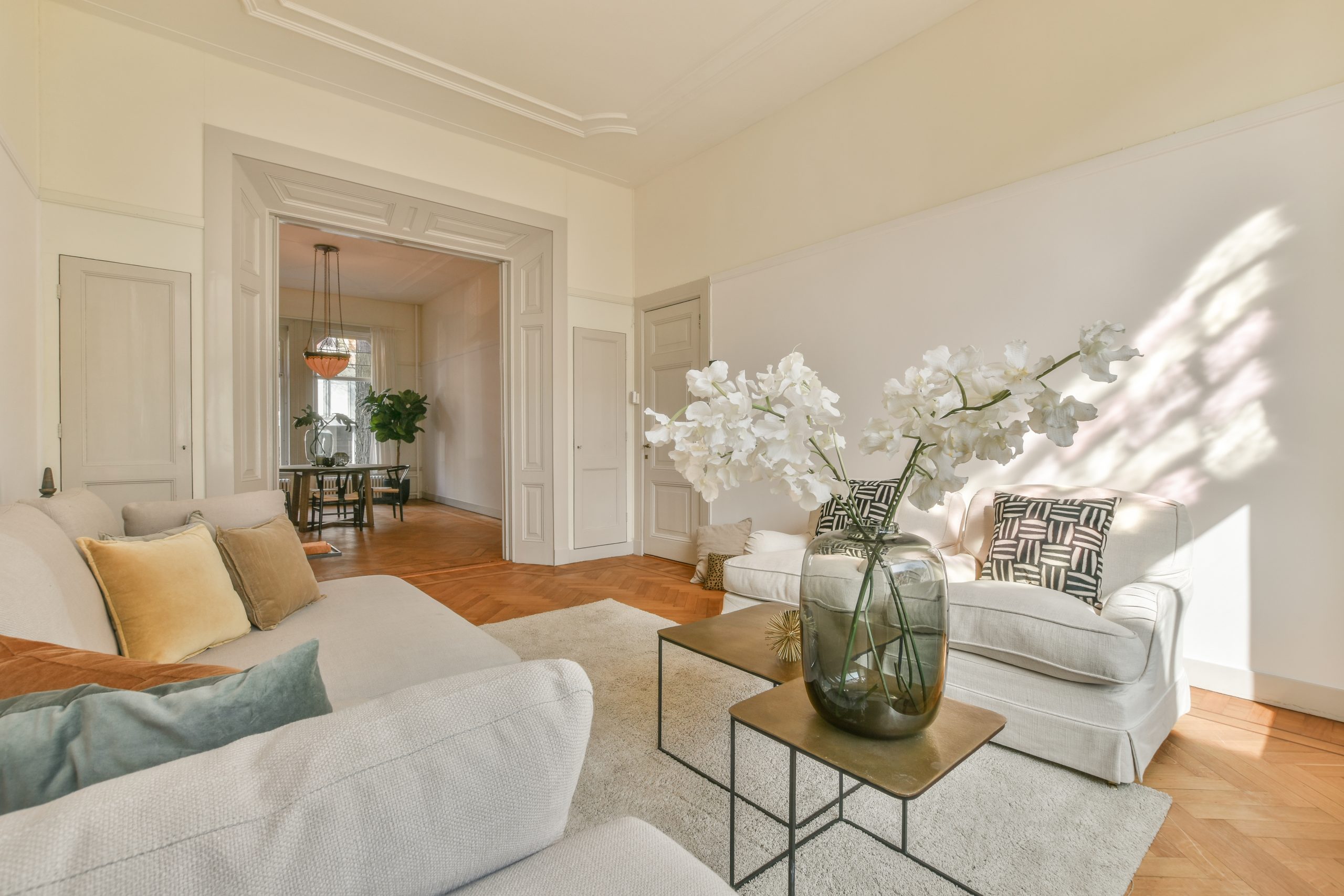 Fancy lamp hanging on ceiling over stylish furniture in spacious living room in modern flat